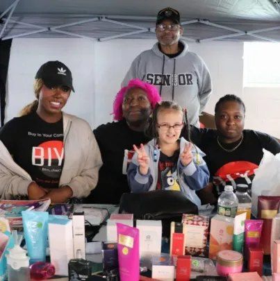 The BIYC team with a young helper at a vendor table