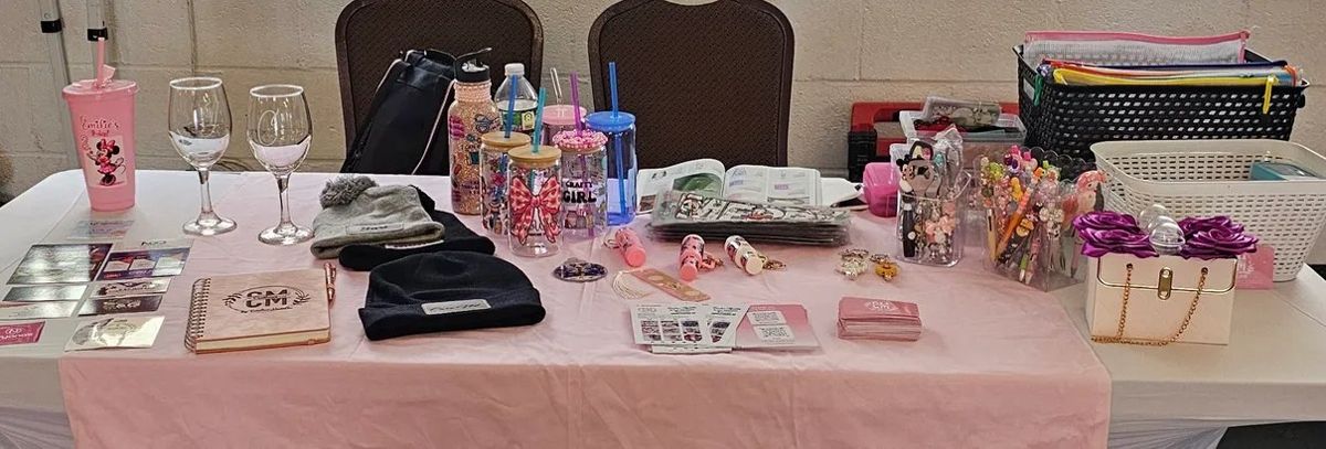 A crafts table with tumblers, pens and gifts